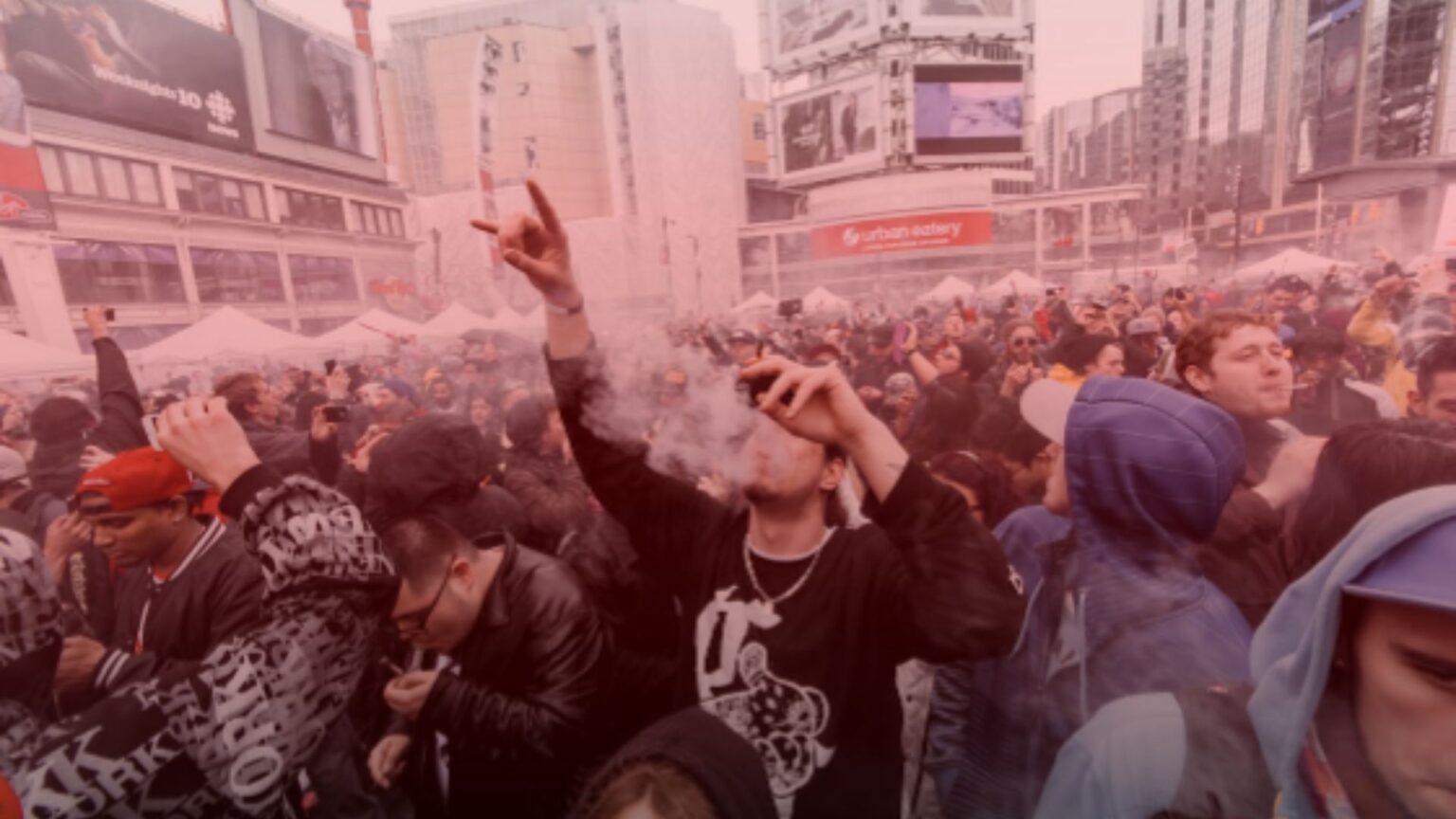 Nature's Canopy House A crowd of people in an urban square, many vaping, with surrounding buildings and advertisements in the background. Dispensary In Mississauga