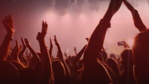 Nature's Canopy House A crowd of people at a concert with raised hands, illuminated by stage lights, celebrating the vibrant energy of global cannabis celebrations. Dispensary In Mississauga