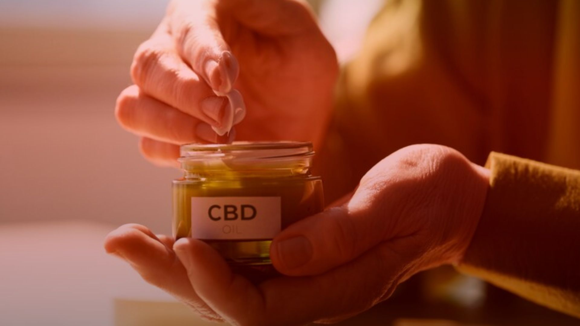 Nature's Canopy House Hands delicately opening a small jar labeled "CBD Oil," reminiscent of an introduction to Dabbing 101 with subtle nods to the rich world of cannabis concentrates. Dispensary In Mississauga