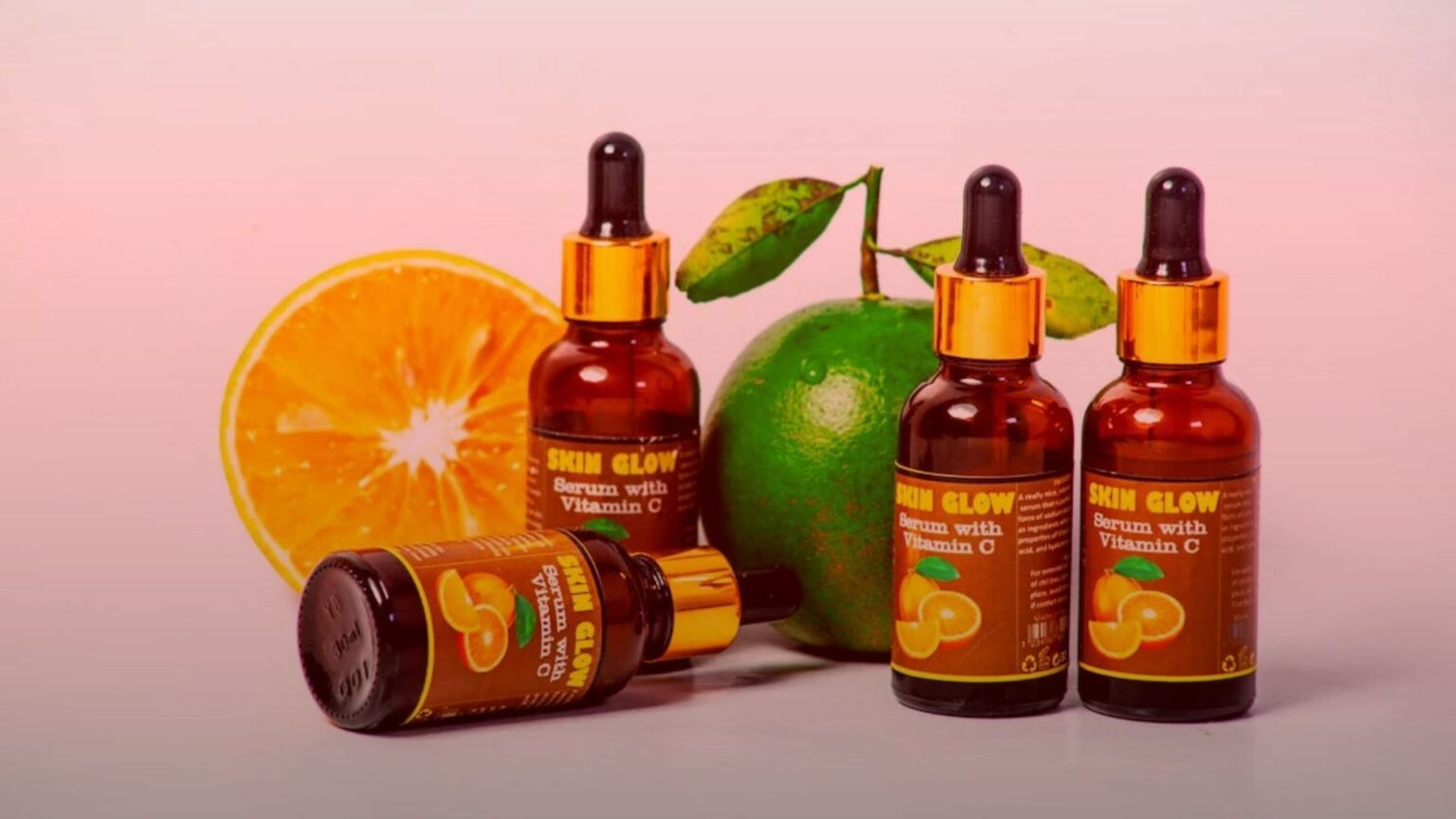 Nature's Canopy House Bottles labeled "Skin Glow Serum with Vitamin C" are elegantly displayed alongside a halved orange and a whole green fruit, hinting at the natural wonder of cannabis topicals. Dispensary In Mississauga